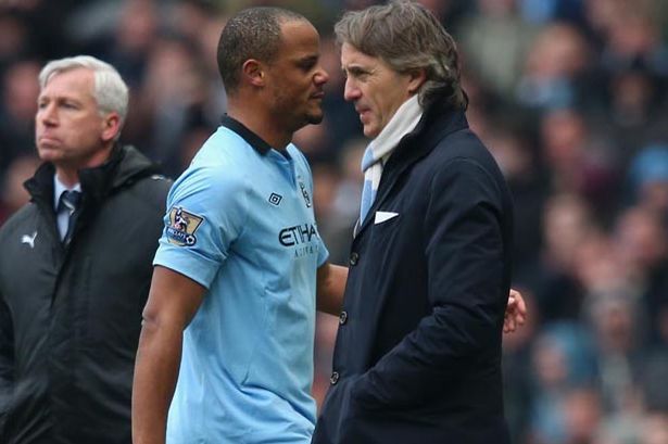 Vincent-Kompany-of-Manchester-City-walks-past-Manager-Roberto-Mancini_zpsb4655d3a.jpg